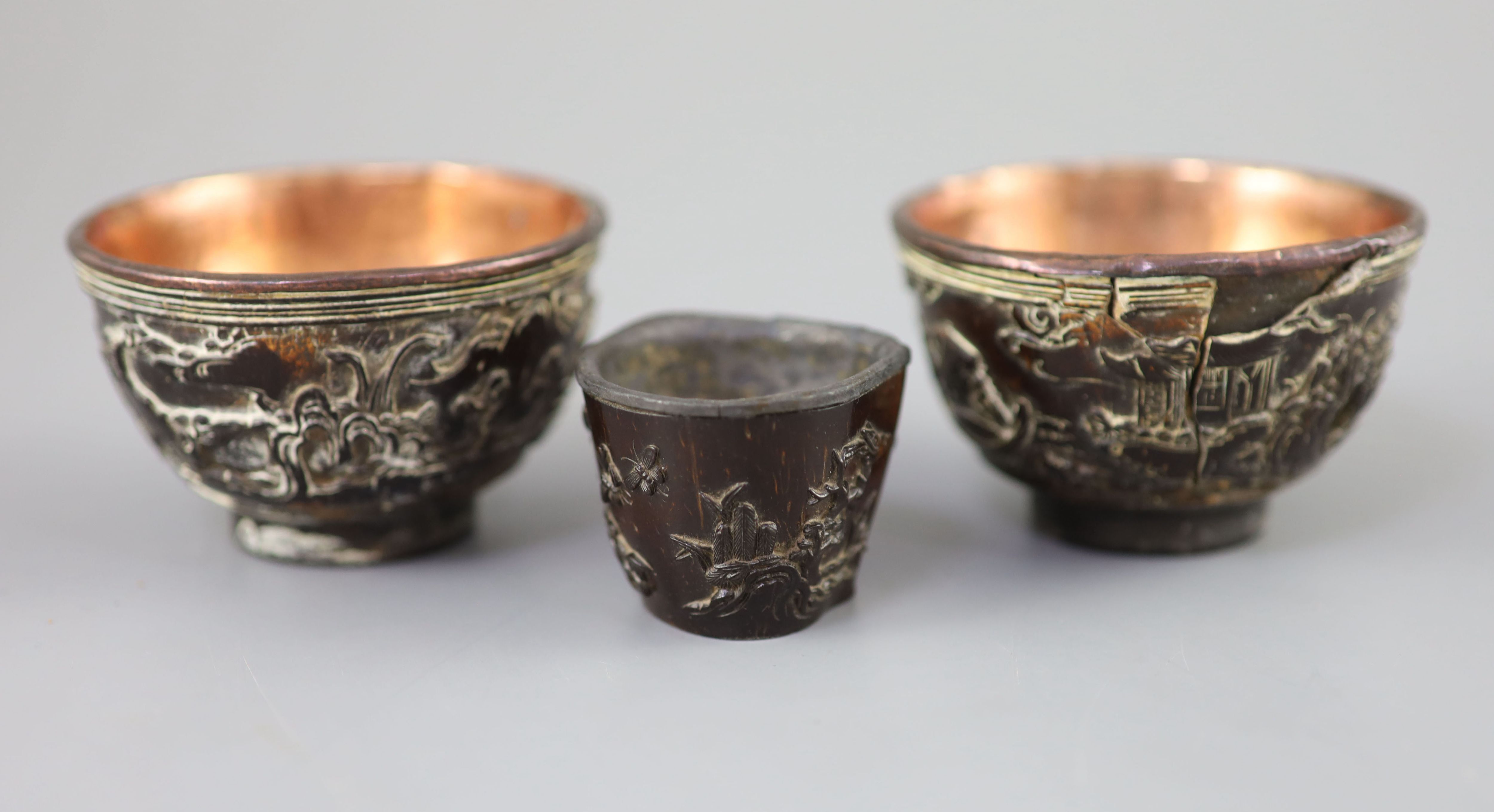A pair of Chinese coconut landscape cups and a similar peach-shaped cup, 18th/19th century,
